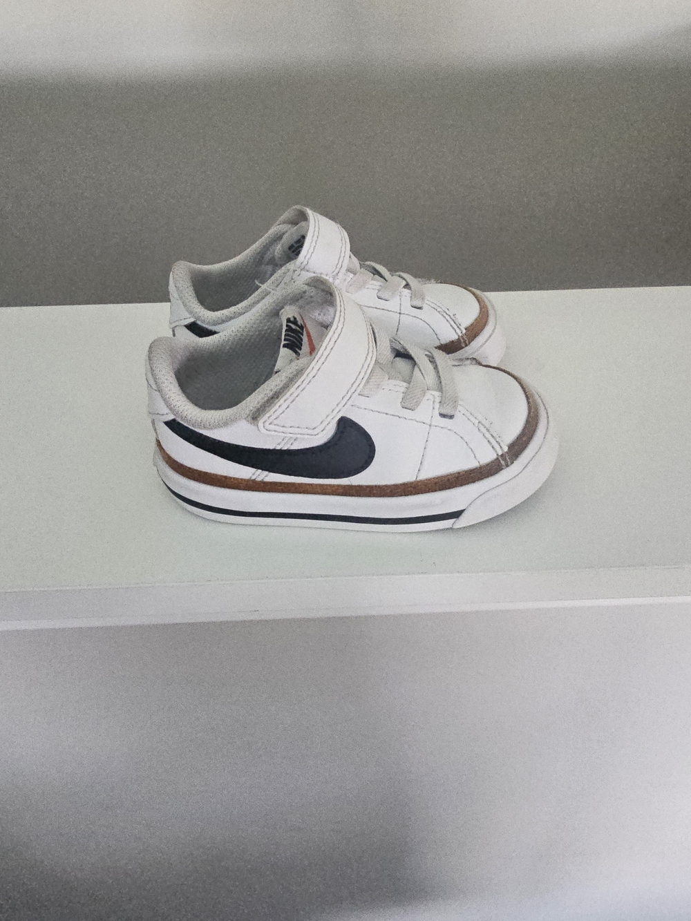 Nike Kids White Sneakers with Black Swoosh and Brown Accent